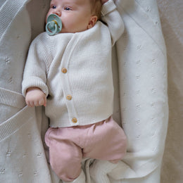 A classic button-front baby top made from 100% RWS certified merino wool. Featuring natural wooden buttons and a ribbed knit design, this sustainable piece combines softness, breathability, and timeless style – perfect for layering all year round.
