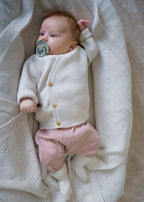 A classic button-front baby top made from 100% RWS certified merino wool. Featuring natural wooden buttons and a ribbed knit design, this sustainable piece combines softness, breathability, and timeless style – perfect for layering all year round.
