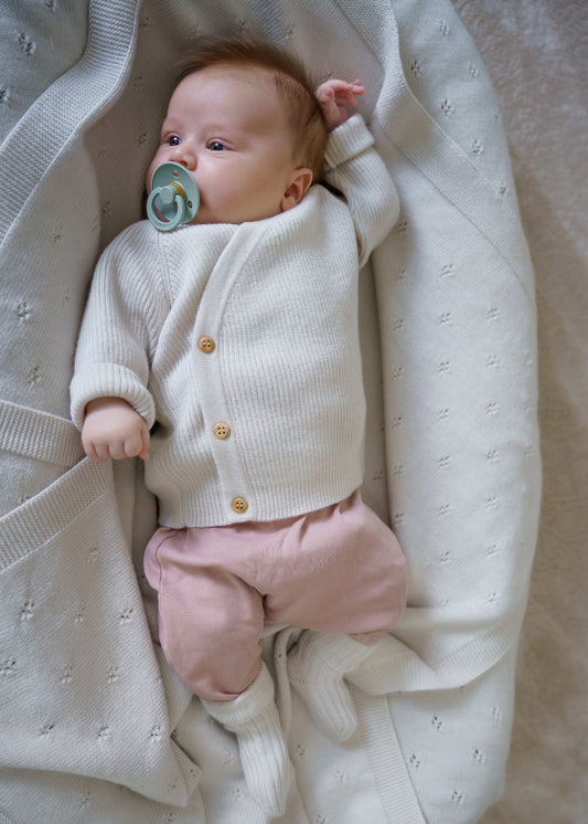 A classic button-front baby top made from 100% RWS certified merino wool. Featuring natural wooden buttons and a ribbed knit design, this sustainable piece combines softness, breathability, and timeless style – perfect for layering all year round.
